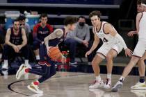 Saint Mary's guard Logan Johnson, left, drives while pressured by Gonzaga forward Corey Kispert ...