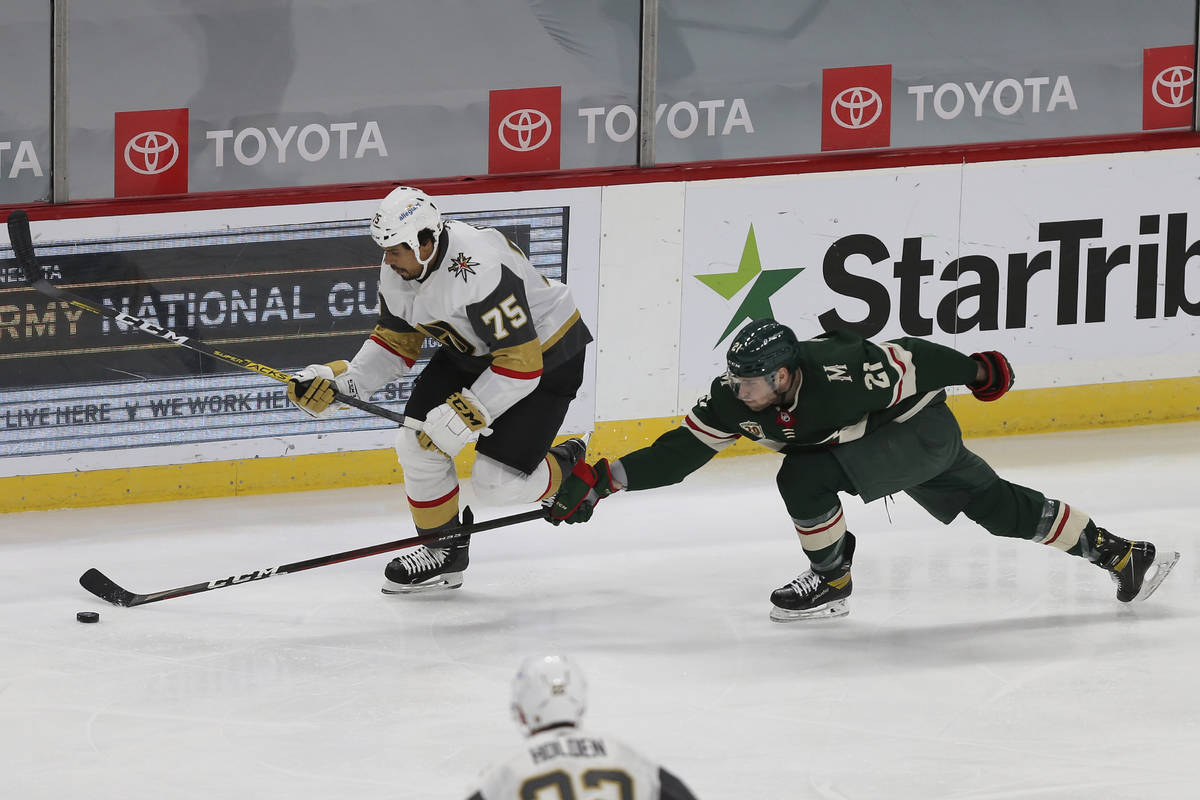 Minnesota Wild's Carson Soucy (21) tries to knock the puck away from Vegas Golden Knights' Ryan ...