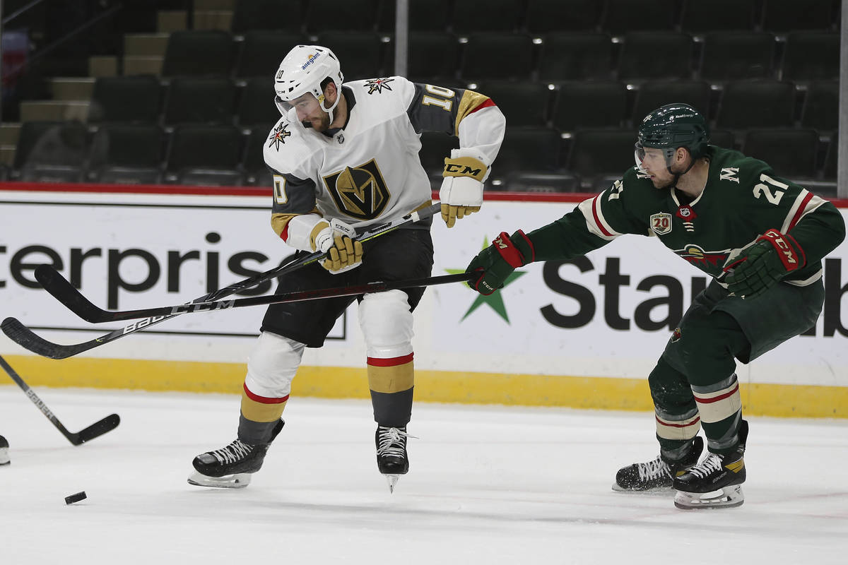 Minnesota Wild's Carson Soucy (21) and Vegas Golden Knights' Nicolas Roy (10) go after the puck ...
