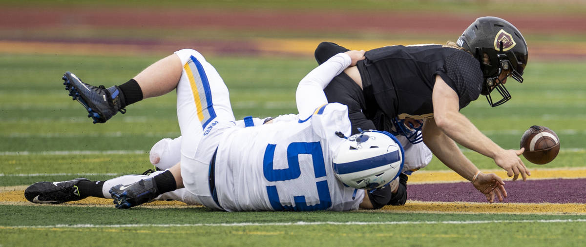 Faith LutheranÕs QB Jaden Turner (10) loses the ball momentarily on a sack by Moapa Valley ...