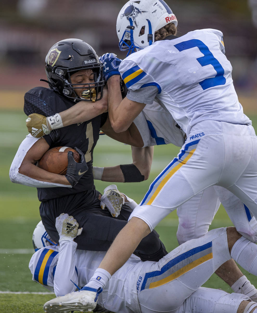 Faith LutheranÕs Josh Goynes (1) is tackled by Moapa ValleyÕs Dustin Gordon (3) and t ...