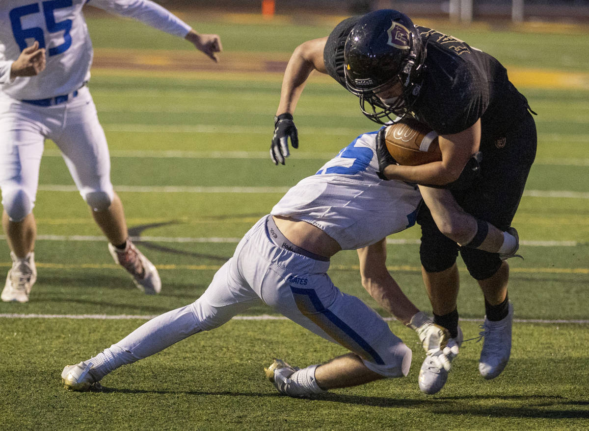 Faith LutheranÕs Marcos Canales (9) is tackled by Moapa ValleyÕs Jayme Carvajal (25) ...