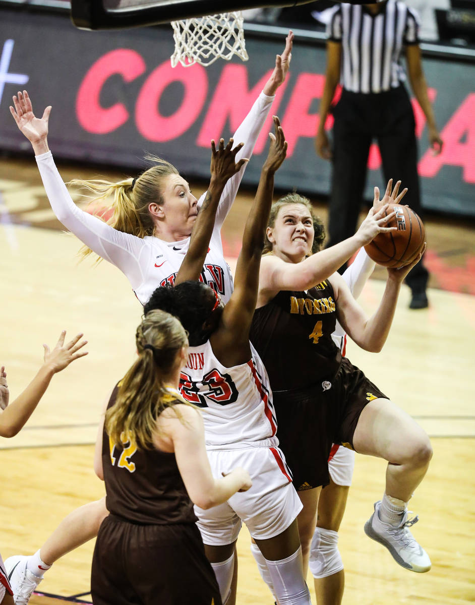 Wyoming Grace Ellis (4) pushes past UNLV center Desi-Rae Young (23) for a basket in the second ...