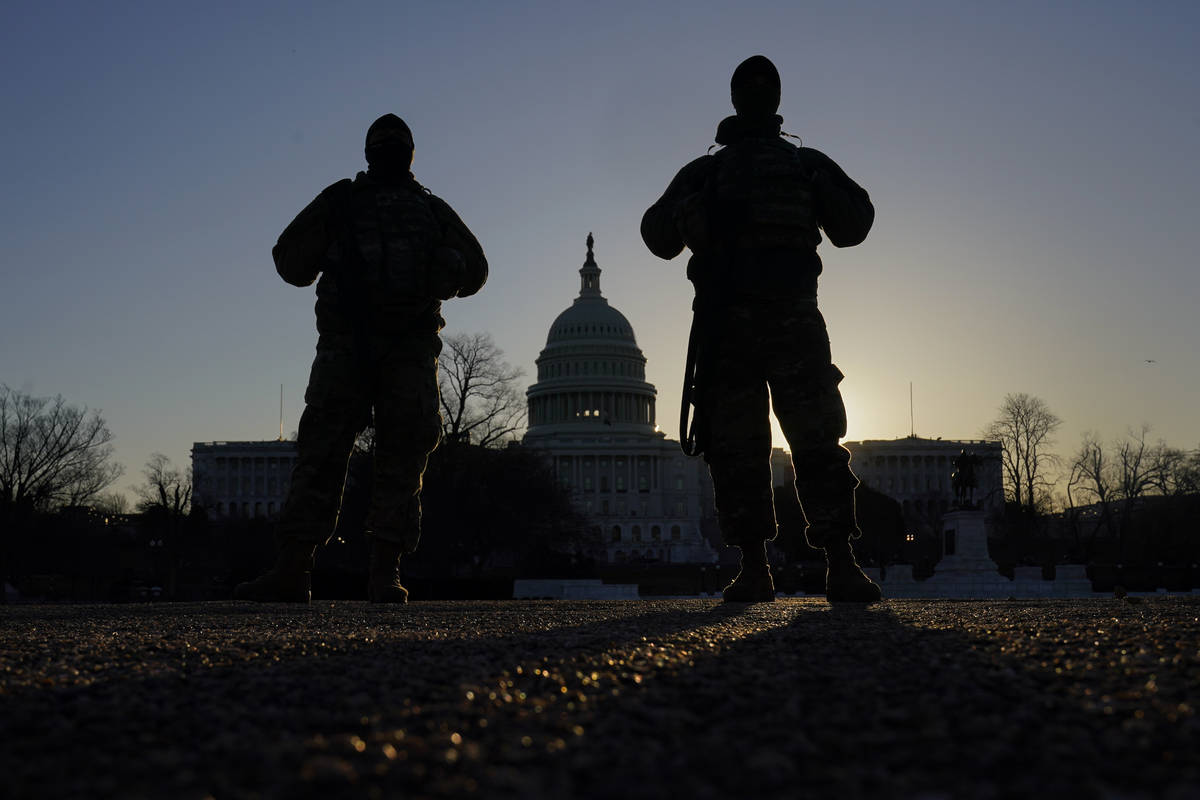 National Guard stand their post at sunrise at the Capitol in Washington, Friday, March 5, 2021. ...