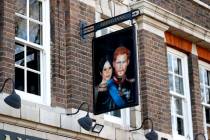 A sign depicting the image of Britain's Prince Harry and his wife Meghan, hangs outside the Duk ...
