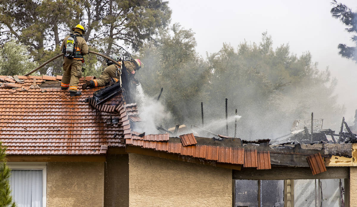 Clark County and Las Vegas Fire Department firefighters work from the rooftop of building 42 du ...