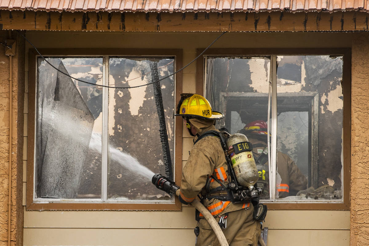 Clark County and Las Vegas Fire Department firefighters work the scene at building 42 during a ...