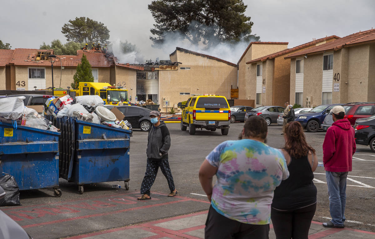 Residents look on as the Clark County and Las Vegas Fire Departments work a fire at Twain Estat ...