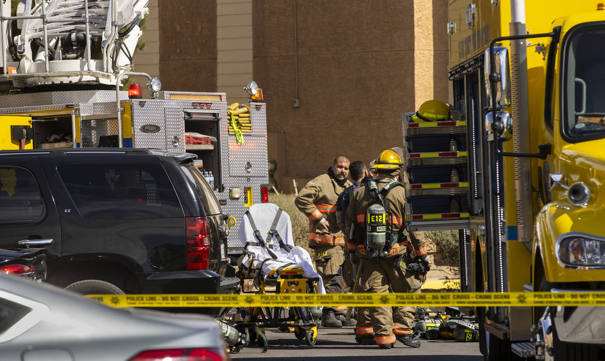 Firefighters walk about the scene as the Clark County and Las Vegas Fire Departments work a fir ...