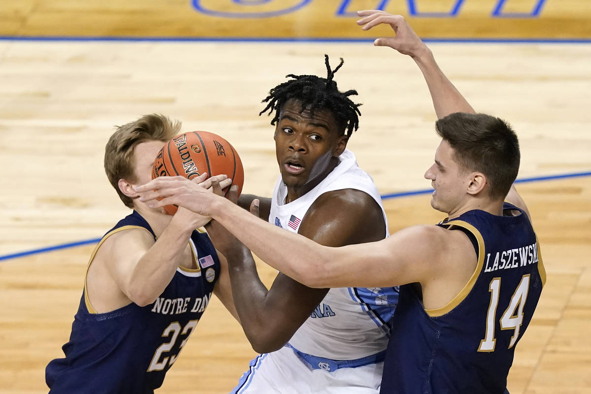 North Carolina forward Day'Ron Sharpe, center, gets pressured by Notre Dame guard Dane Goodwin ...