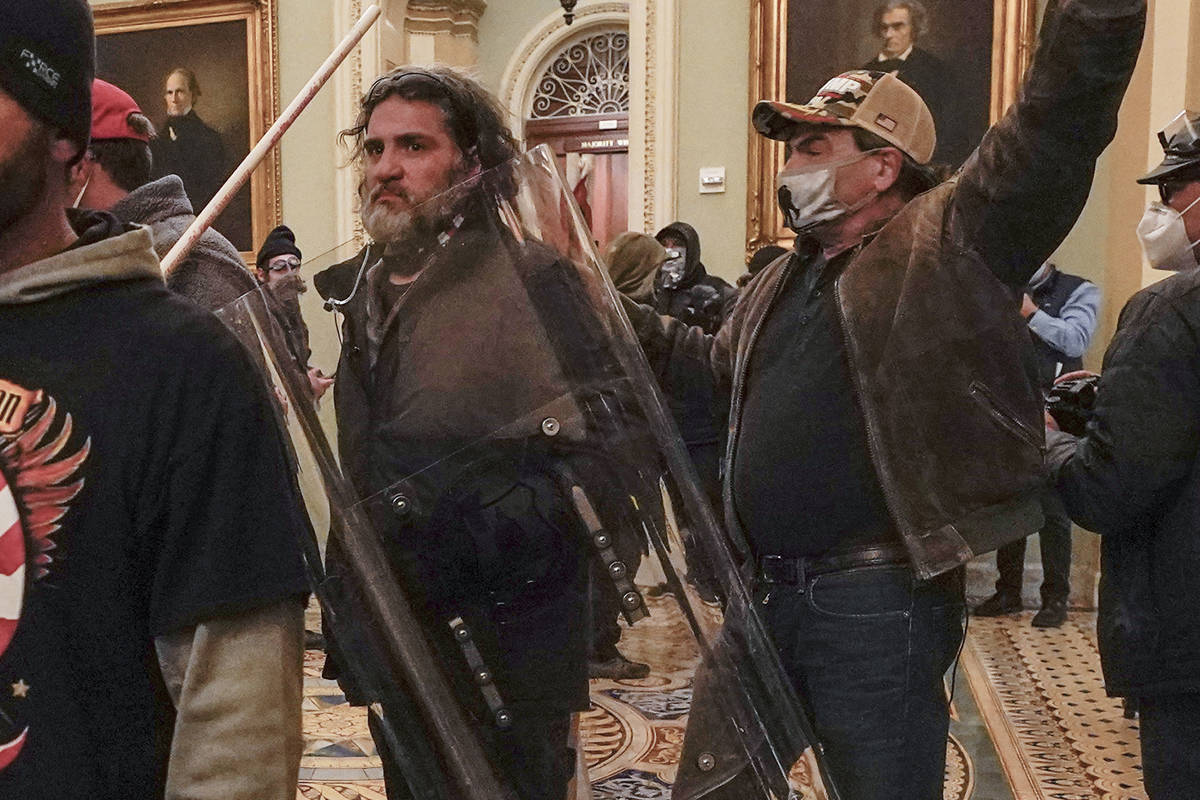In this Jan. 6, 2021, photo, rioters, including Dominic Pezzola, center with police shield, are ...