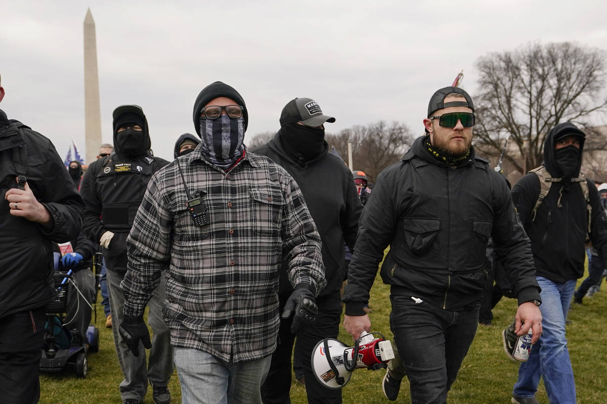 In this Jan. 6, 2021, photo, Proud Boy members Joseph Biggs, left, and Ethan Nordean, right wit ...