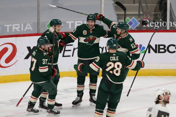 Minnesota Wild's Carson Soucy (21), center, celebrates with teammates on the ice after he score ...