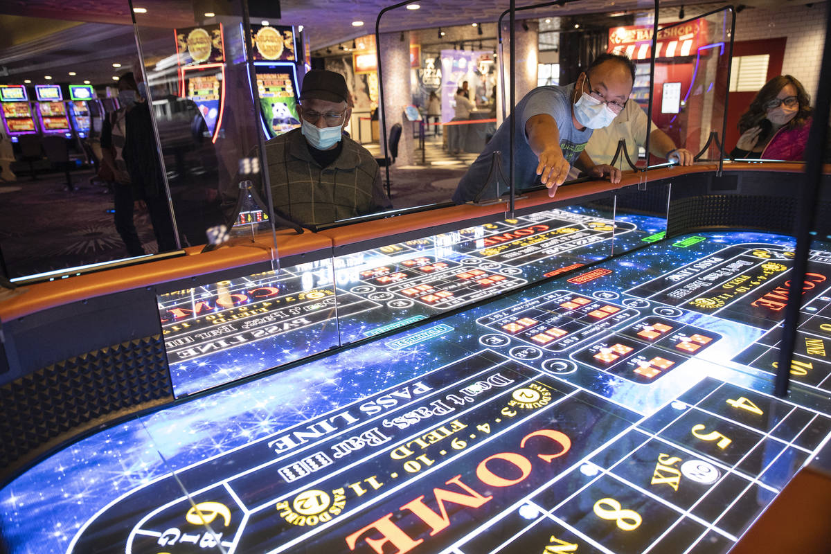 Rio Bencito of Los Angeles rolls dice on the new digital craps table, Rolls to Win Craps, at th ...