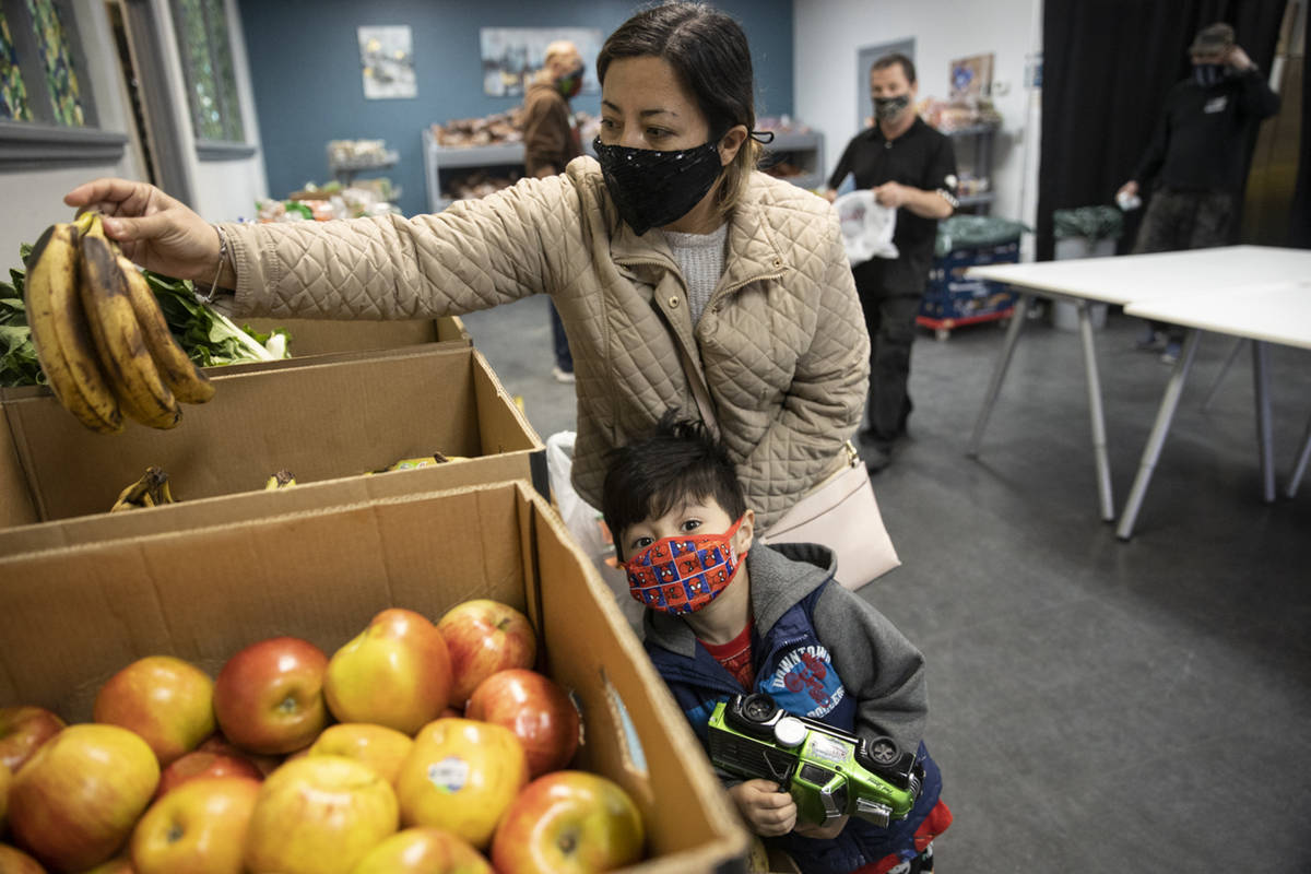 Yulissa Peña with her 4-year-old son Yadiel, selects bananas at the City Impact Urban Food ...