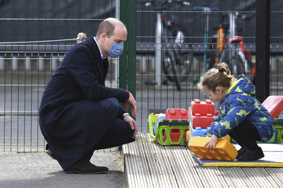 Britain's Prince William watches a child in the playground during a visit with Kate, Duchess of ...