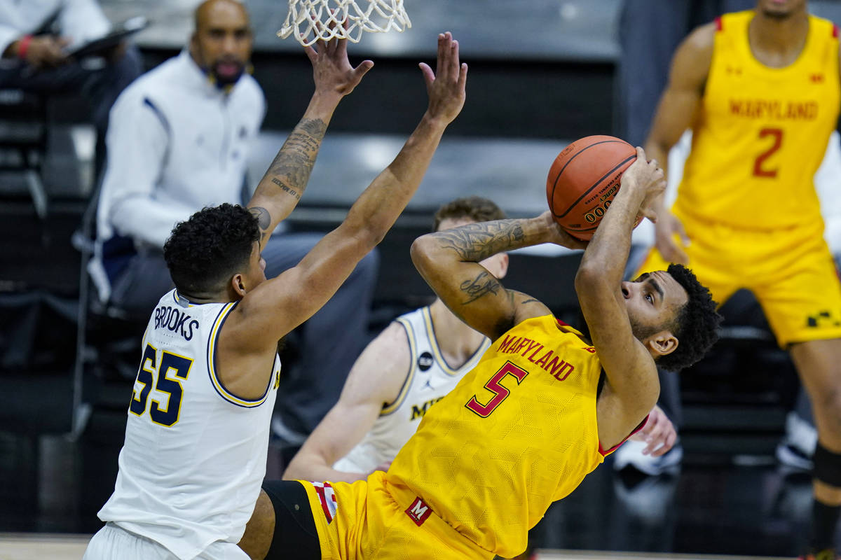 Maryland guard Eric Ayala (5) shoots over Michigan guard Eli Brooks (55) in the first half of a ...