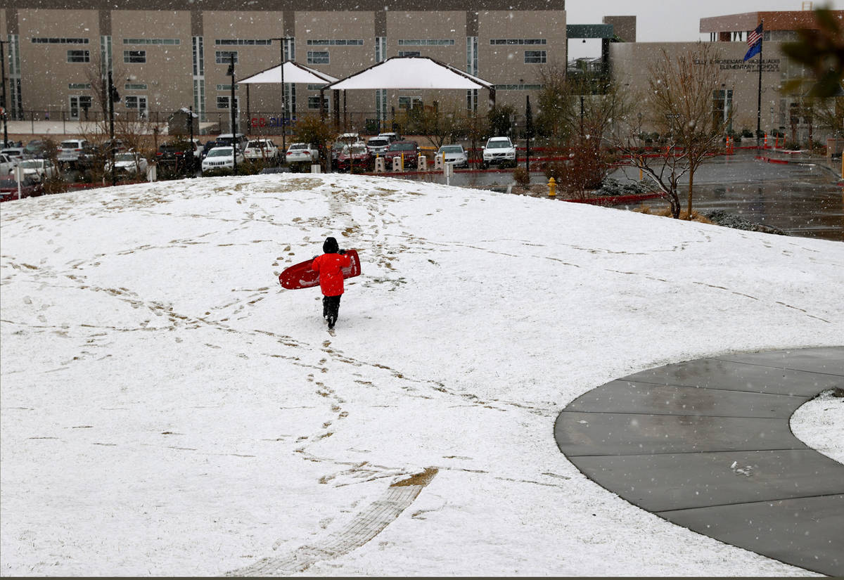Nik Provenzano, 5, of Las Vegas, plays under a light snow at Fox Hill Park in Summerlin in Las ...