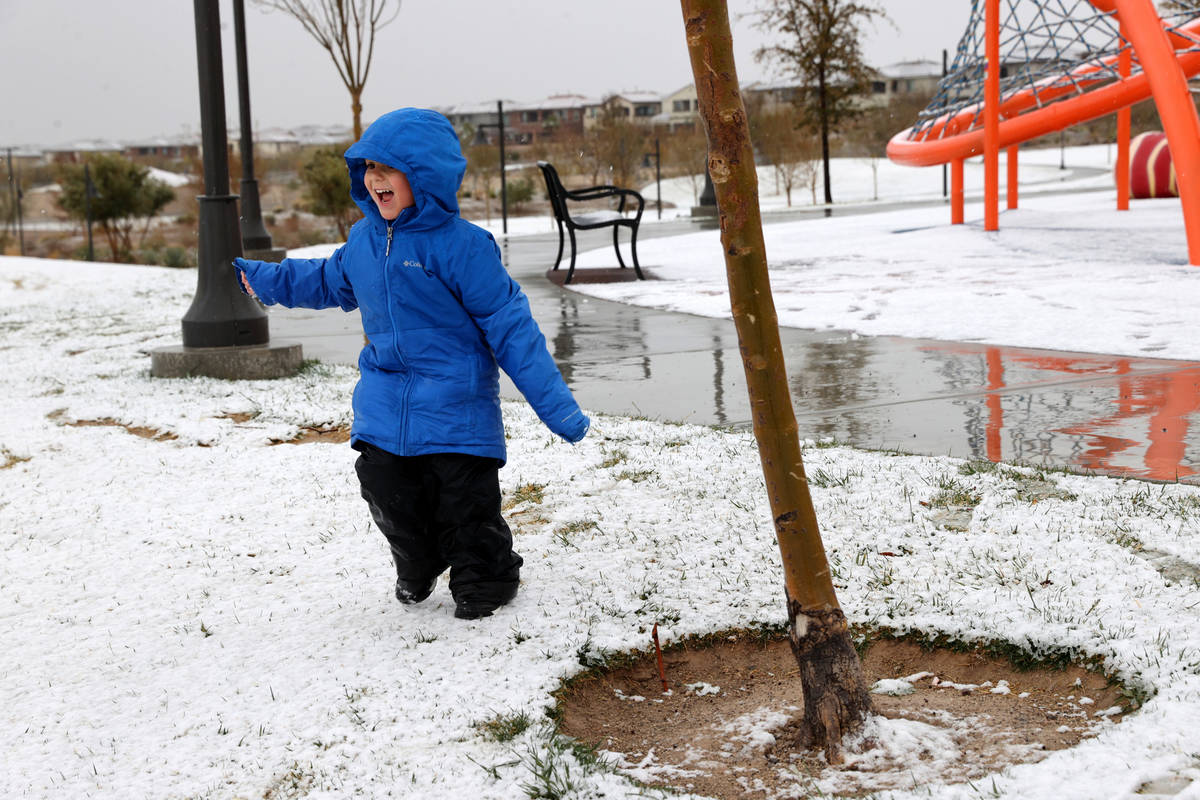 Nilin Provenzano, 3, of Las Vegas, plays under a light snow at Fox Hill Park in Summerlin in La ...