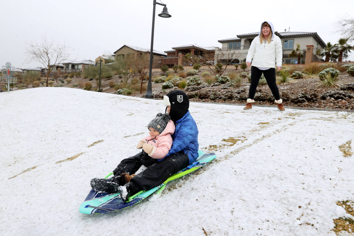Landon Morris, 9, of Las Vegas, takes his sister Collins, 1, for a sled ride in the snow as the ...