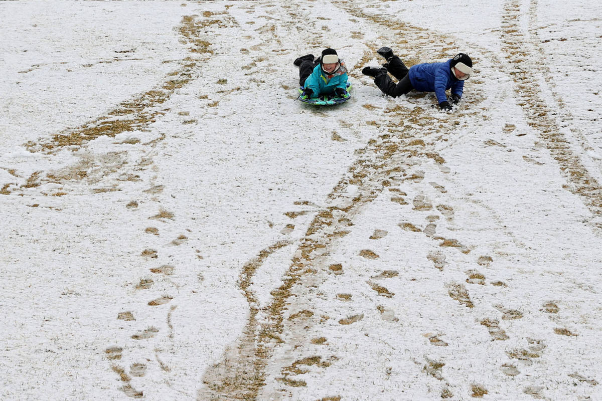 Oliver Morris, 7, and his brother Landon, 9, of Las Vegas, play in the snow at Fox Hill Park in ...