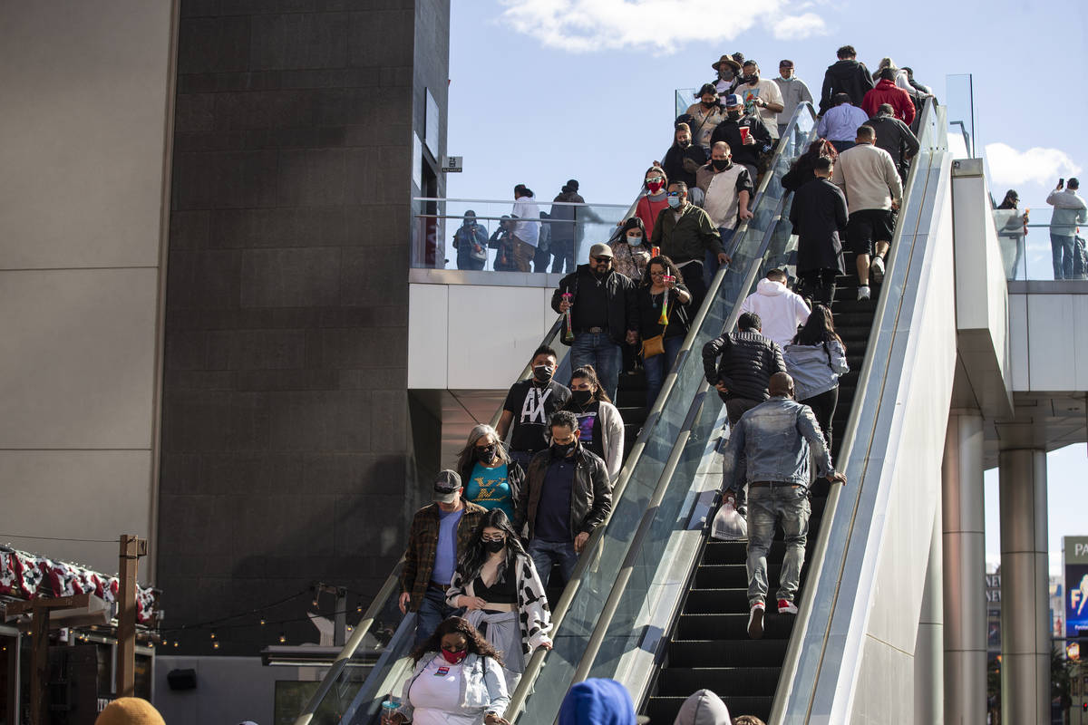 People visit the Strip near the Planet Hollywood hotel-casino in Las Vegas, on Saturday, March ...
