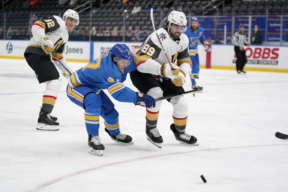 Vegas Golden Knights' Alex Tuch (89) and St. Louis Blues' Torey Krug (47) chase after a loose p ...