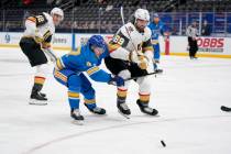 Vegas Golden Knights' Alex Tuch (89) and St. Louis Blues' Torey Krug (47) chase after a loose p ...