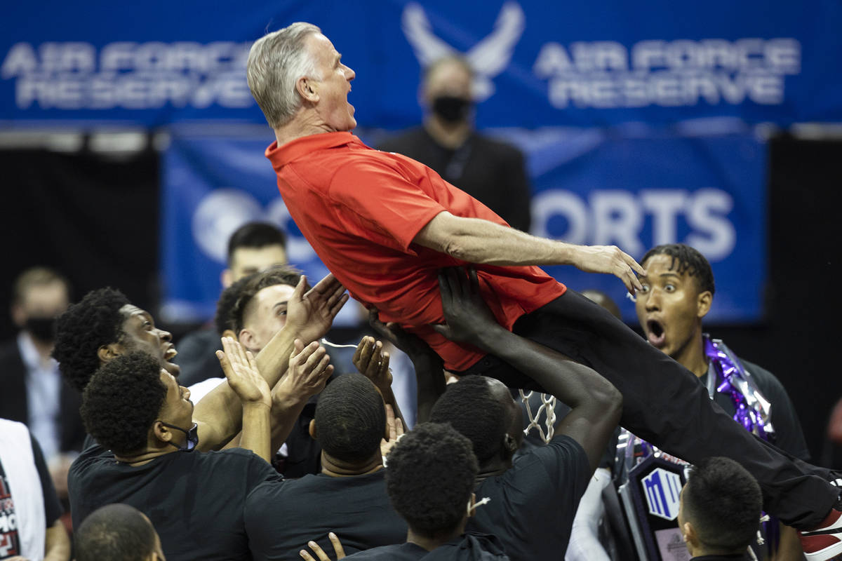 San Diego State Aztecs head coach Brian Dutcher celebrates with a trust fall into his players a ...