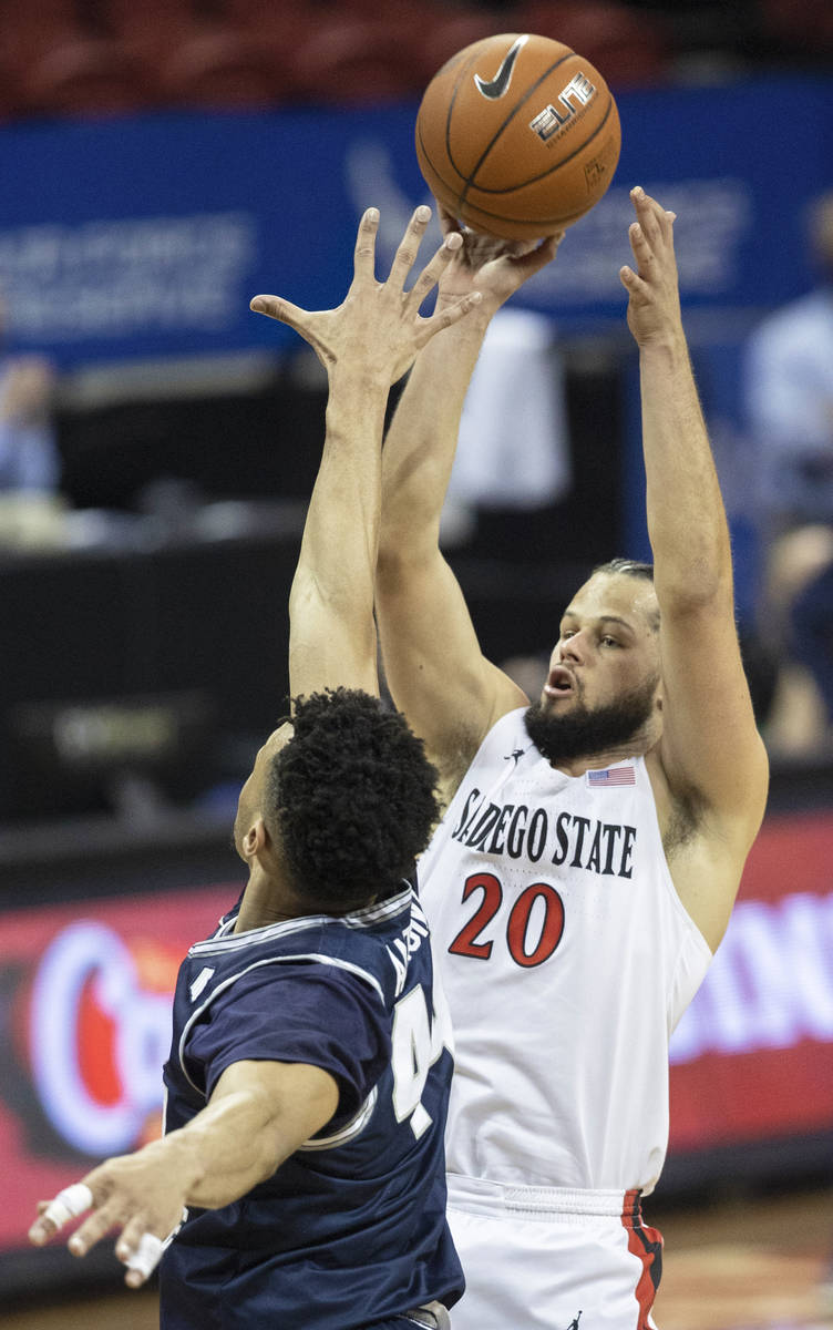 San Diego State Aztecs guard Jordan Schakel (20) shoots over Utah State Aggies guard Marco Anth ...