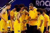 Michigan head coach Juwan Howard meets with his team during the first half of an NCAA college b ...
