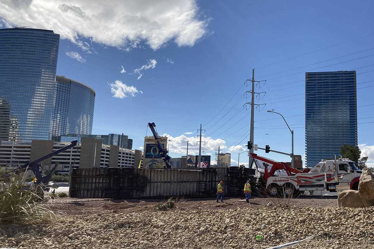 Crews work on an overturned semitractor-trailer Monday, March 15, 2021, on the eastbound Flamin ...
