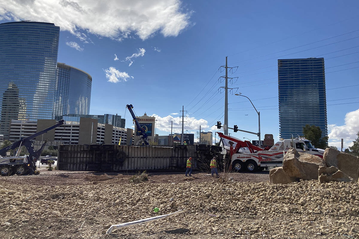 Crews work on an overturned semitractor-trailer Monday, March 15, 2021, on the eastbound Flamin ...