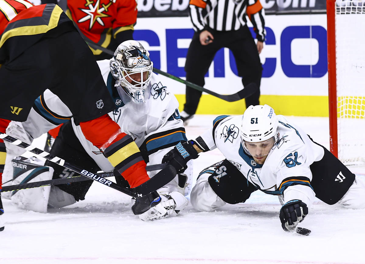 San Jose Sharks' Radim Simek (51) reaches for the puck alongside goaltender Devan Dubnyk (40) d ...