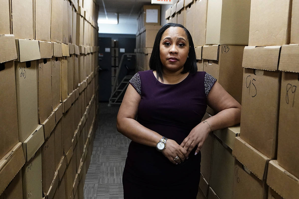 Fulton County District Attorney Fani Willis poses among boxes containing thousands of primal ca ...