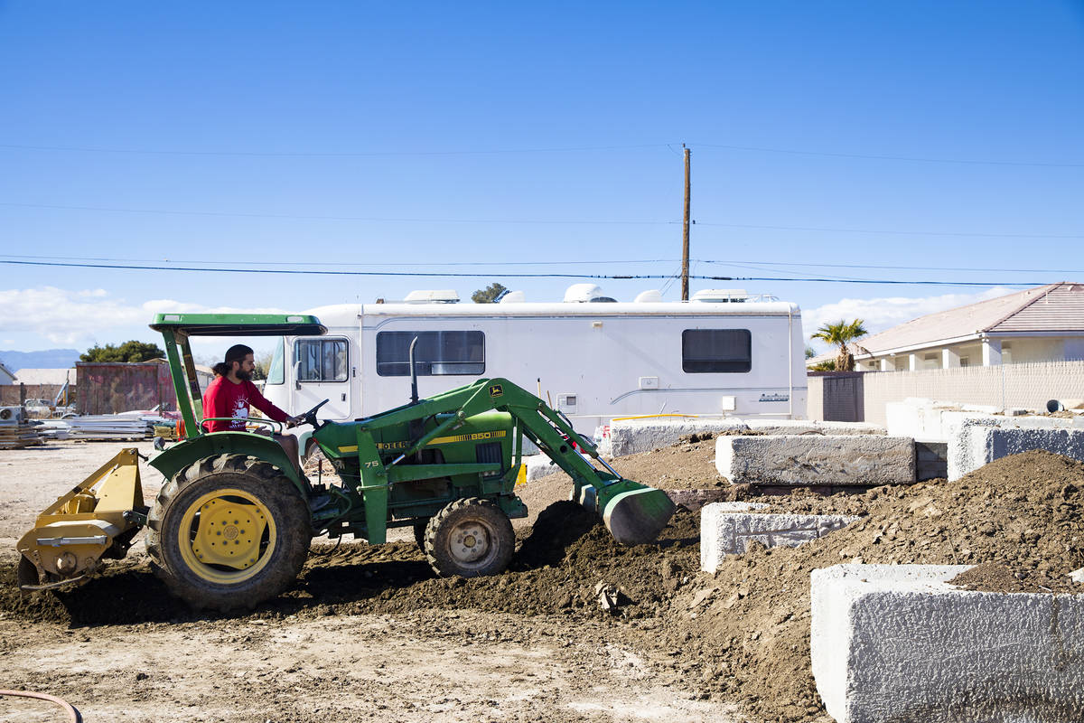 Volunteer T.J. Kerner aerates the soil in a compost pile so the compost process continues its w ...