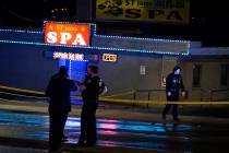 Law enforcement officials confer outside a massage parlor following a shooting on Tuesday, Marc ...