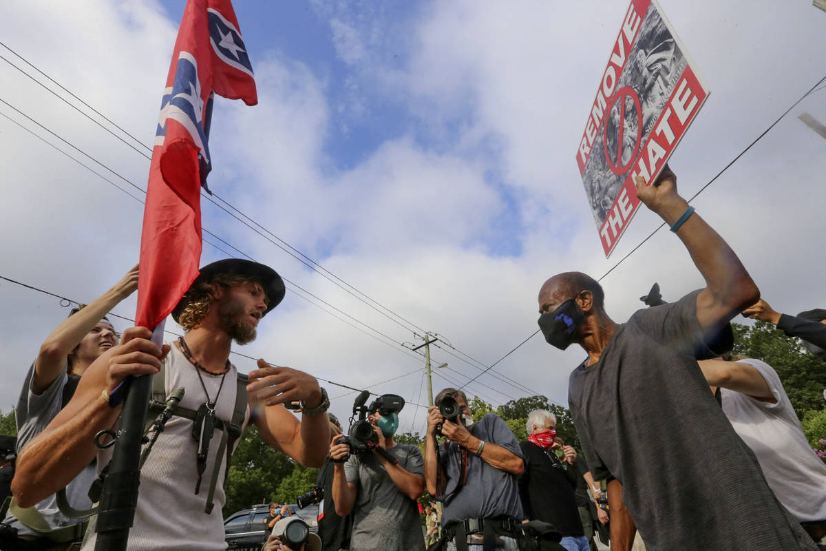 In this Aug. 15, 2020, file photo, protesters and counter-protesters face off in Stone Mountain ...
