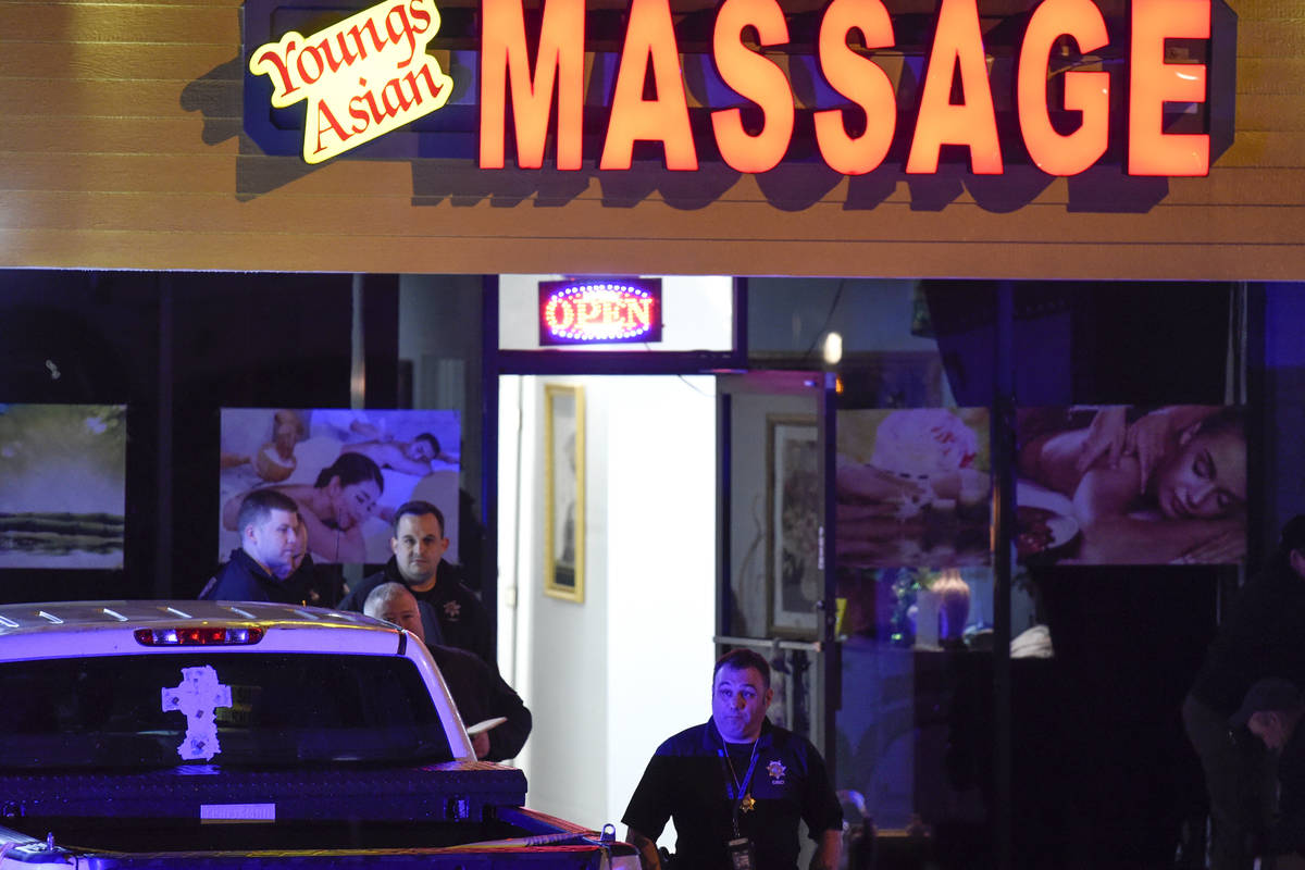 Authorities investigate a fatal shooting at a massage parlor, late Tuesday, March 16, 2021, in ...