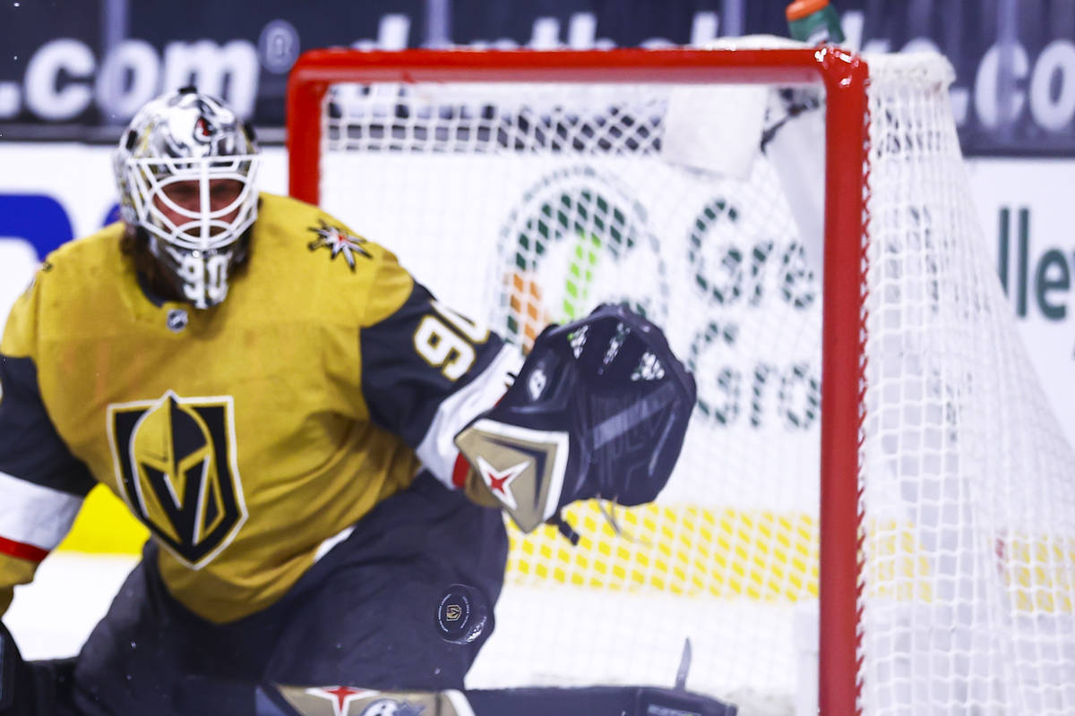 The puck flies past Golden Knights goaltender Robin Lehner (90) during the first period of an N ...
