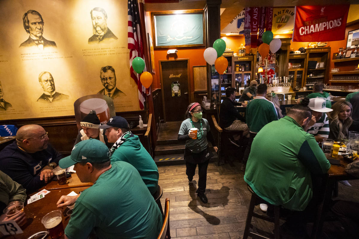 Jennifer Calabrese, right, serves drinks as people gather to celebrate St. Patrick's Day at McM ...