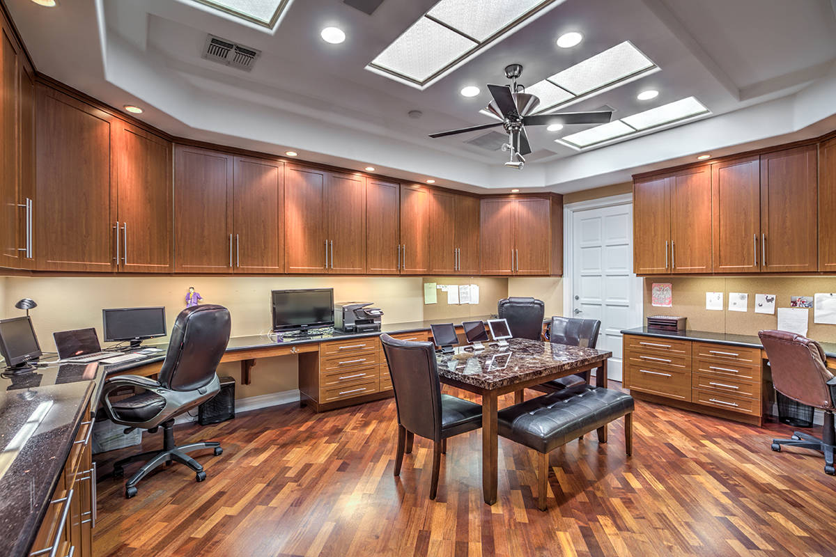 The home has a collaborative workspace that has five granite-topped computer stations and cente ...