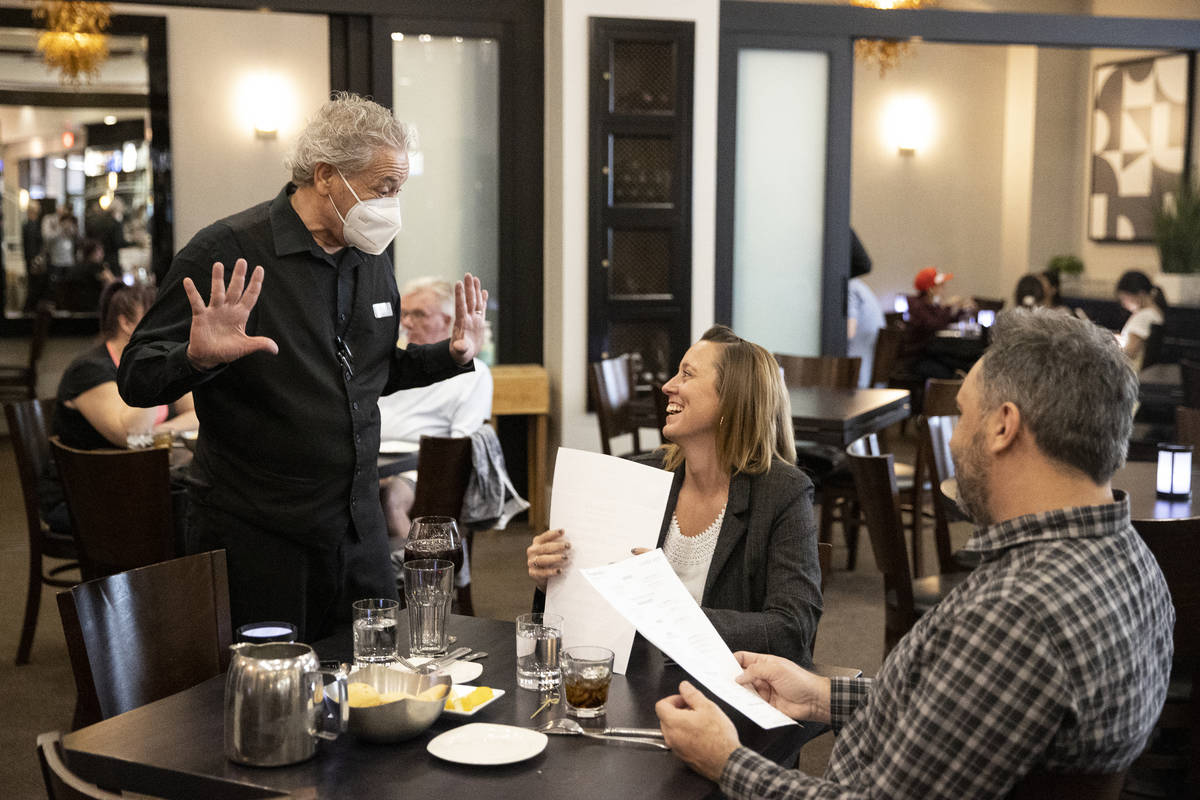 Server Virgilio Ferraro speaks to customers Jill Clark and her boyfriend Geoffrey Schierbaum of ...