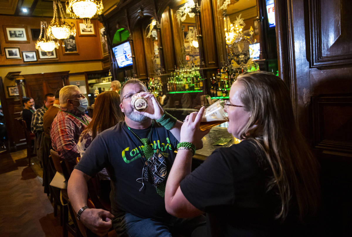Paul Fink and Regina Gordon, both of Phoenix, drink by the bar as people gather to celebrate St ...