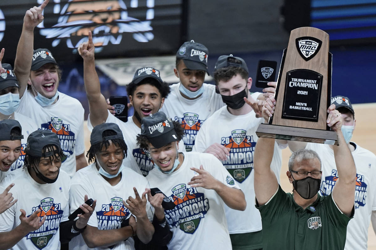 Ohio head coach Jeff Boals holds up the trophy as teammates celebrate after Ohio defeated Buffa ...