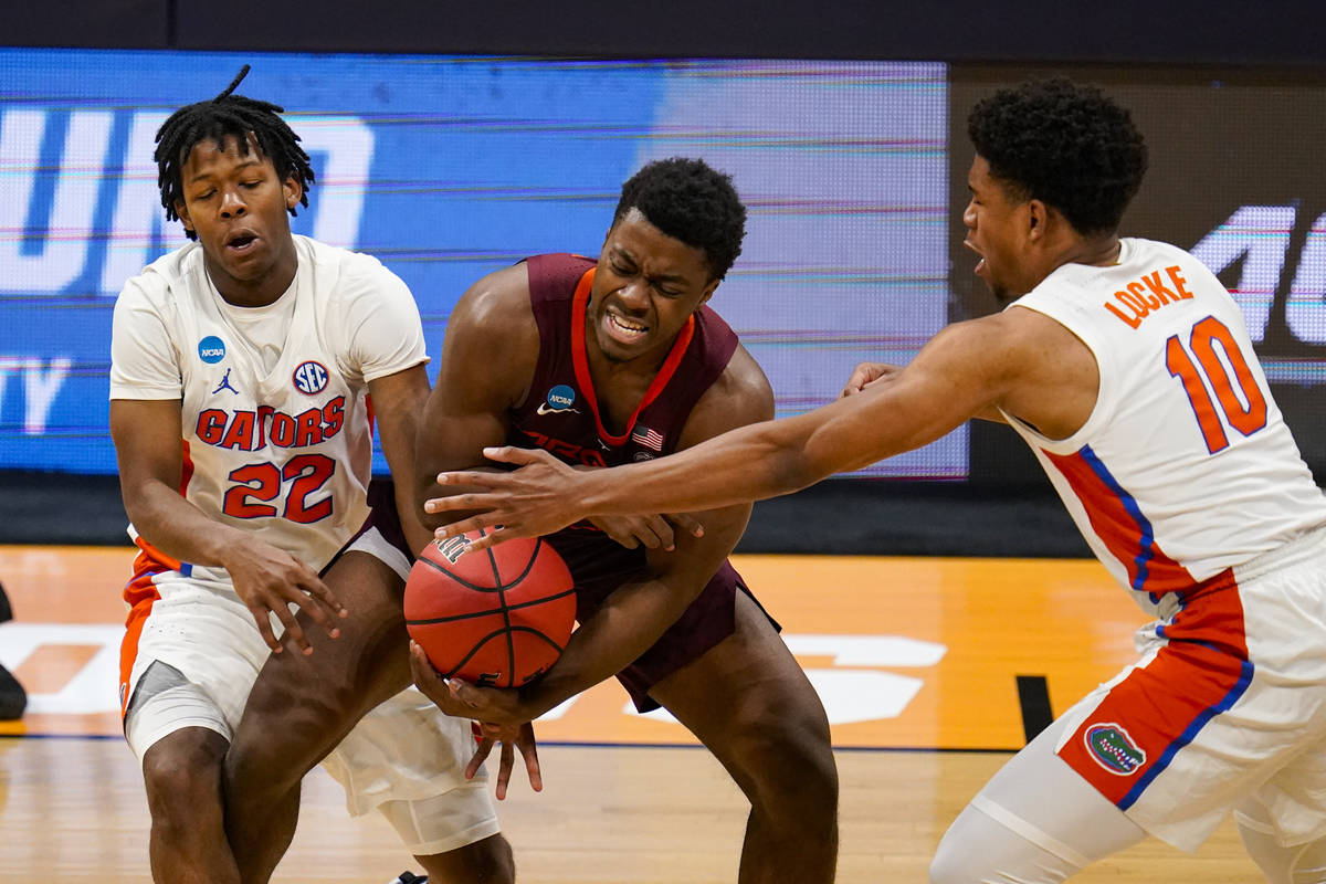 Virginia Tech guard Nahiem Alleyne (4), center, is trapped by Florida guards Tyree Appleby (22) ...