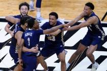 Oral Roberts players celebrate at the end of a college basketball game against Florida in the s ...