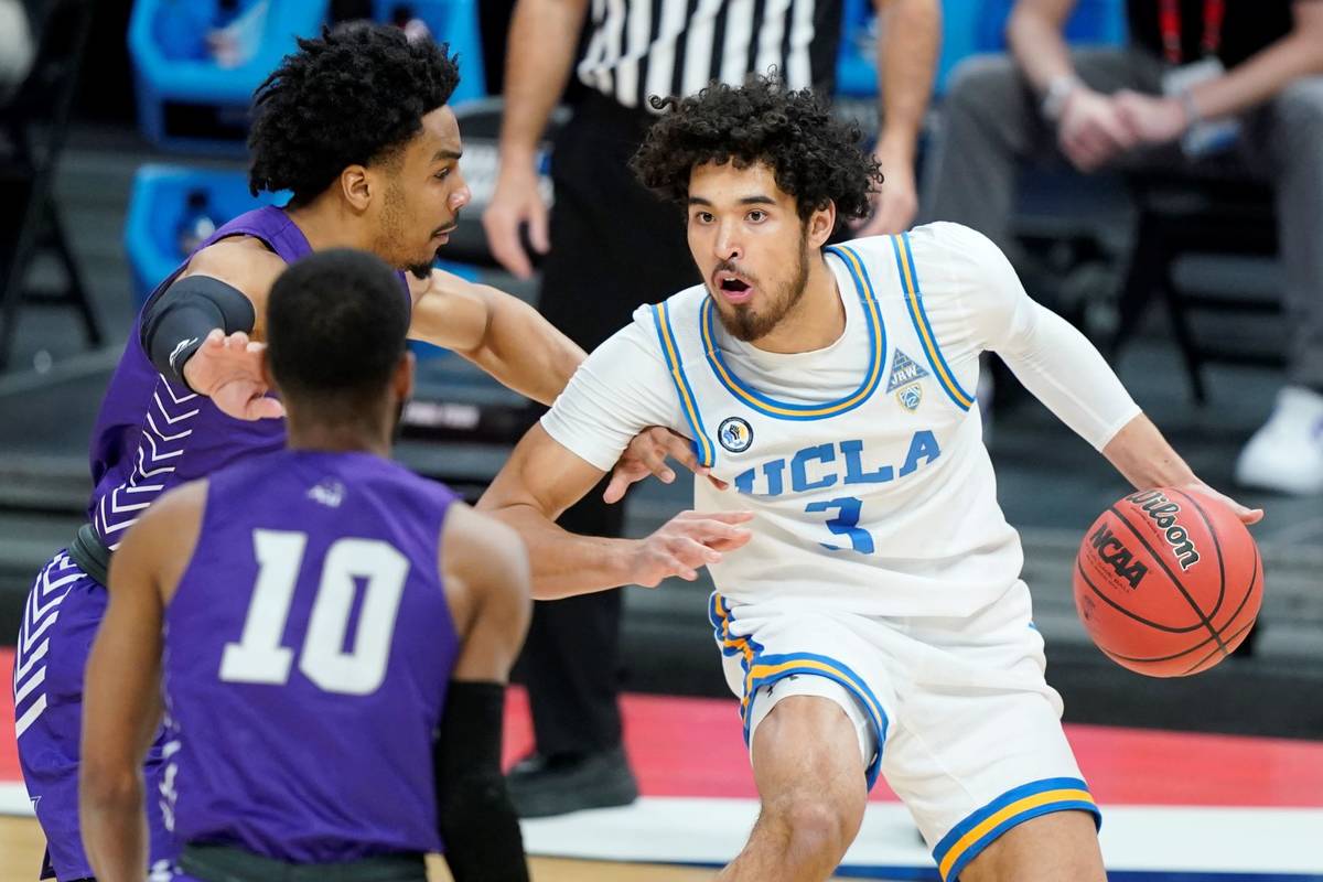UCLA's Johnny Juzang (3) is defended by Abilene Christian's Coryon Mason, left, and Reggie Mill ...