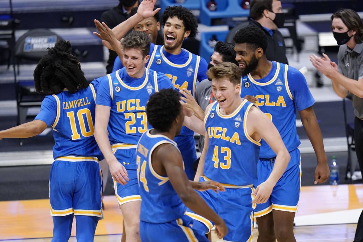 UCLA basketball players celebrate their win over BYU after a first-round game in the NCAA colle ...