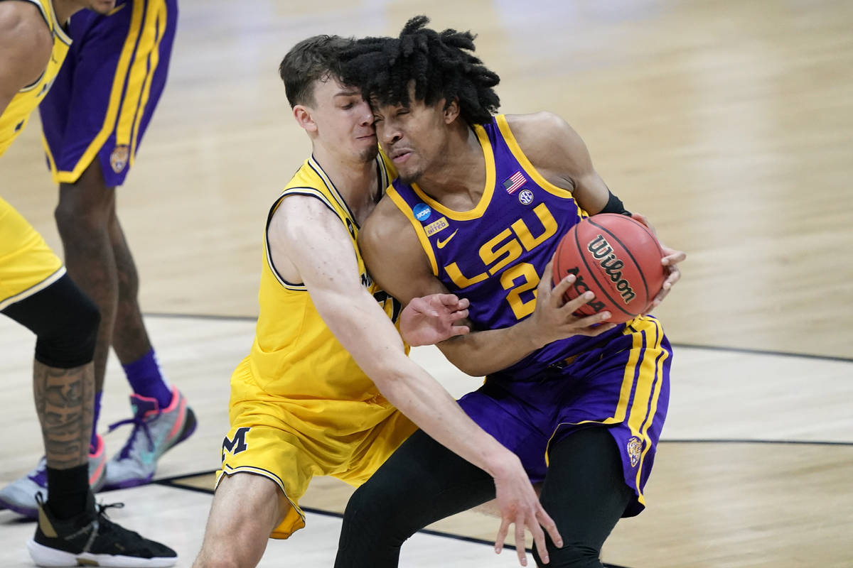 Michigan guard Franz Wagner, left, tries to steal the ball from LSU forward Trendon Watford (2) ...